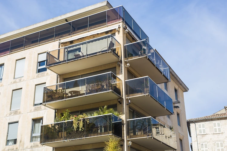 wohngebäude mit modernen balkons aus verdunkeltem glas und aluminium in der stadt