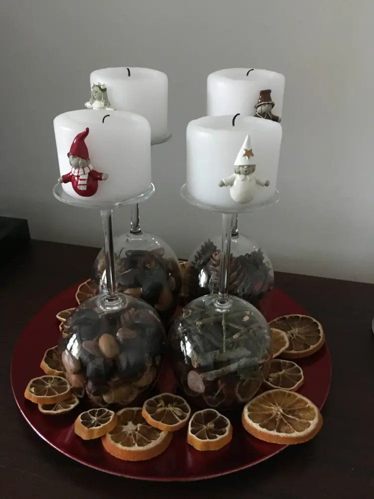 Adventskranz mit Weingläsern auf einem Deko-Teller mit Orangenscheiben