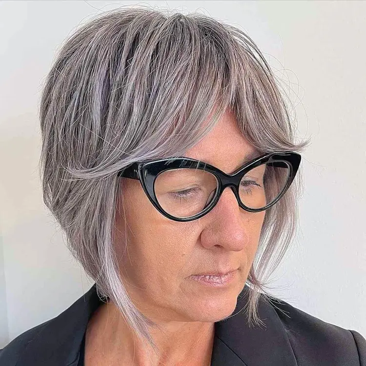 Kurzhaarfrisur für graue Haare mit Curtain bangs und Brille