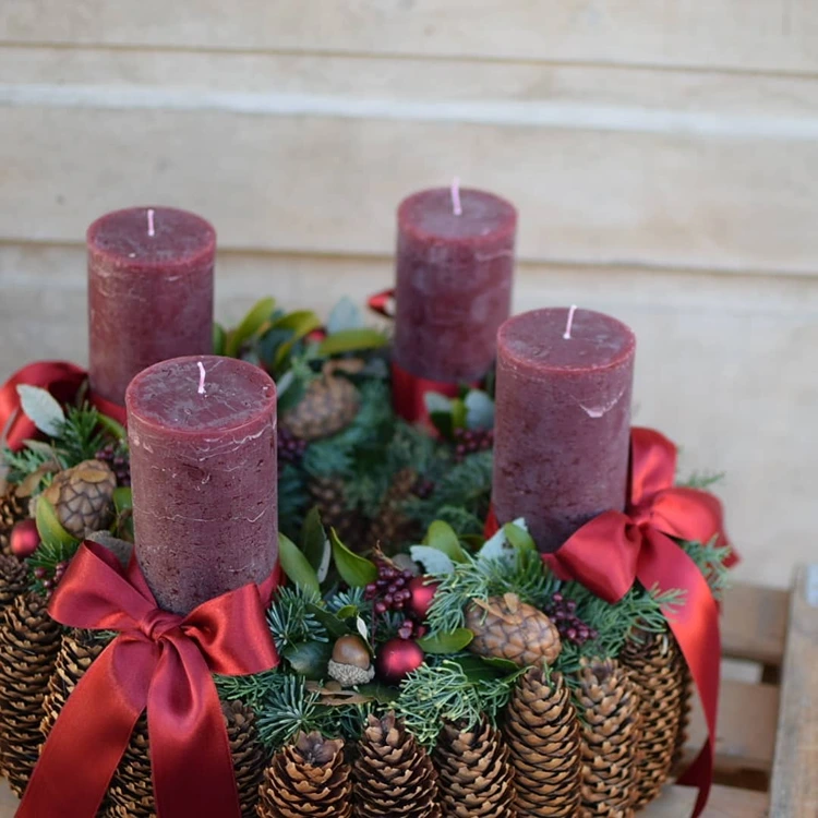 adventskranz mit zapfen roten schleifen und rustikalem charme