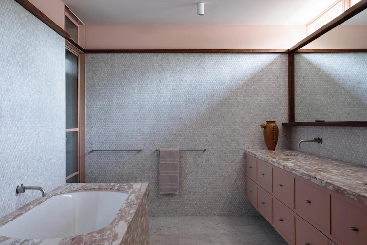 dunkle holzrahmen und winzige badfliesen mit oberflächen aus marmor in einem bad mit wanne kombinieren