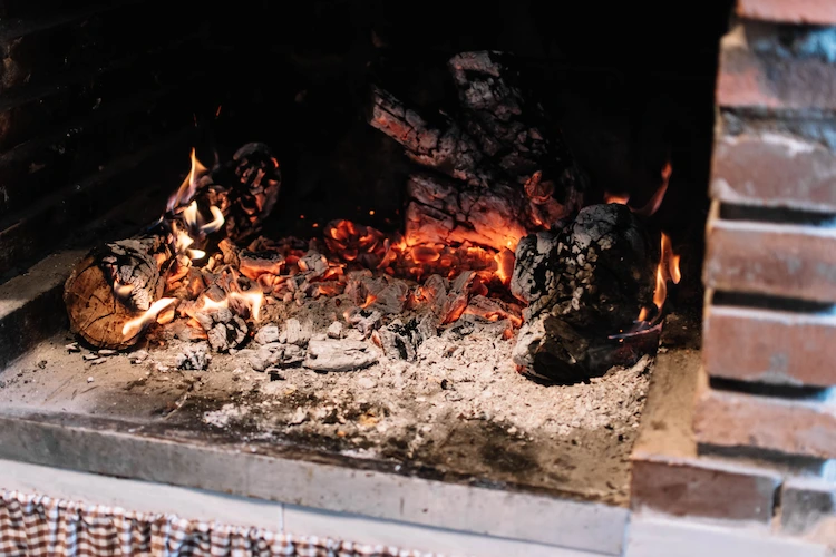 heiße glut und kohleasche vorsichtig aus kamin entfernen und vergiftung durch kohlenmonoxid vorbeugen