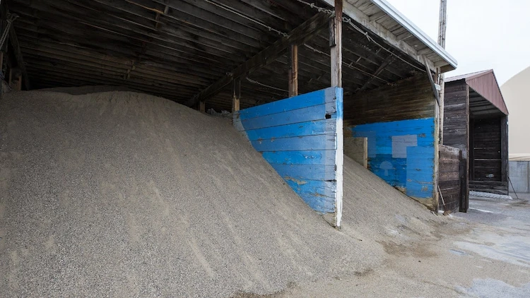riesige haufen vom sand als alternative zu streusalz bei eisigen straßen und autobahnen im winter verwenden