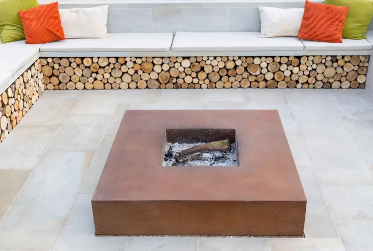 stilvoll und minimalistisch gestalteter außenbereich mit feuerstelle aus cortenstahl und sitzgelegenheiten