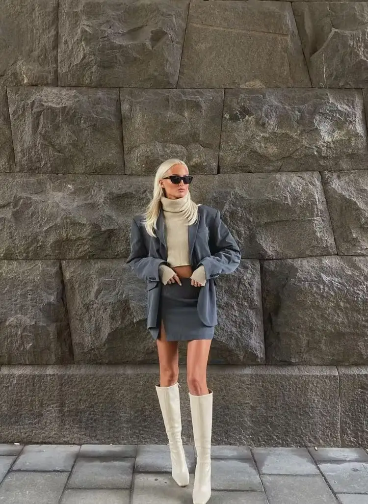 Ein sehr trendiges und elegantes Winter-Outfit ist der Minirock mit kniehohen Stiefeln zu kombinieren