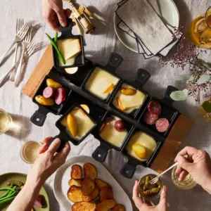 Raclette Tisch decken - Einzelne Käseportionen werden in kleine Pfännchen, sogenannte Coupelles, gelegt,