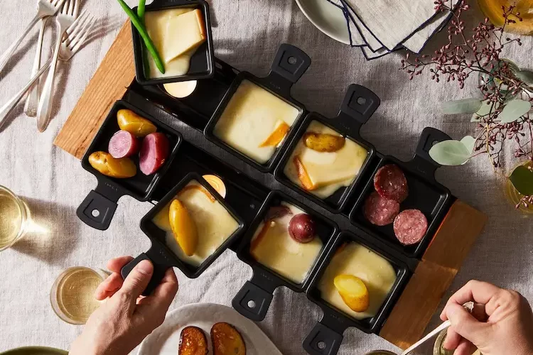 Raclette Tisch decken - Einzelne Käseportionen werden in kleine Pfännchen, sogenannte Coupelles, gelegt,