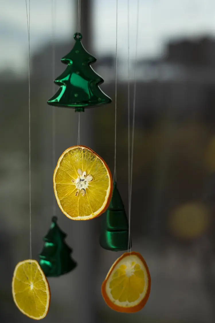 Schöner Fensterschmuck für Weihnachten mit Orangen und Weihnachtsbaumschmuck