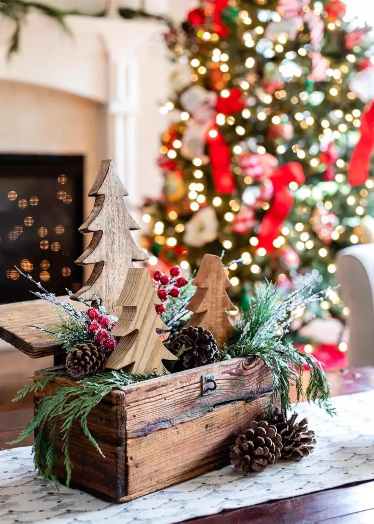 Schöne Weihnachtsdeko für den Couchtisch mit grünen Zweigen Zapfen und Holz-Tannenbäumen