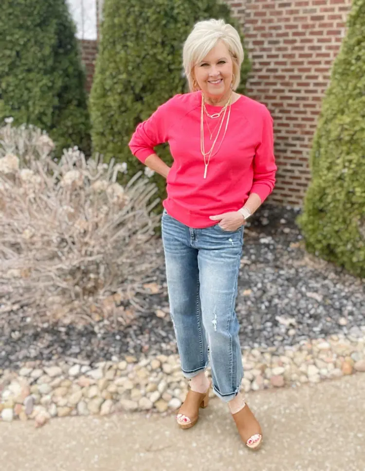 Welche Farben ab 60 vermeiden - Die richtige Jeans mit pinkem Pullover kombinieren