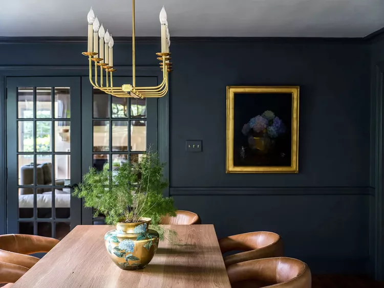 dunkle farbtöne wie tiefes blau mit holz und goldfarbenen elementen als wohnzimmer trends 2023 vereinen