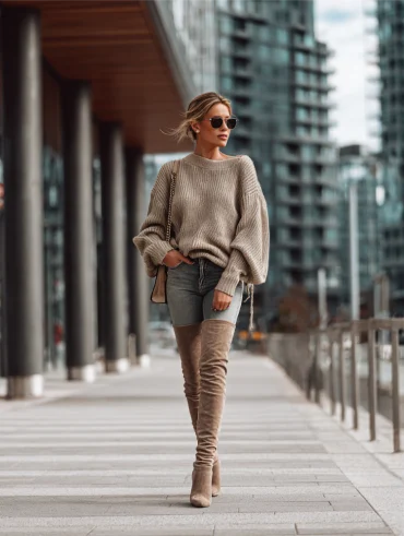 frau mit beigen overknee stiefeln, skinny jeans und beigem pullover