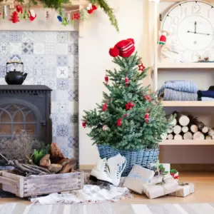 rustikal eingerichtetes wohnzimmer mit holzofen und dezent dekoriertem weihnachtsbaum