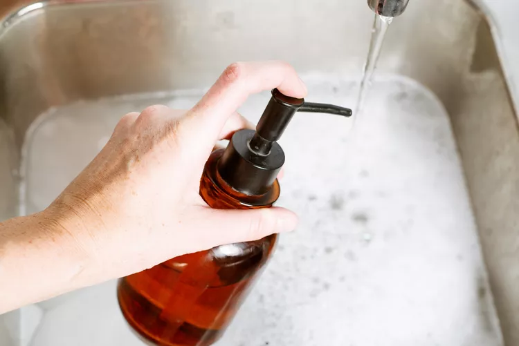 seifenwasser mit spülmittel im waschbecken machen und diverse haushaltsgegenstände darin abspülen