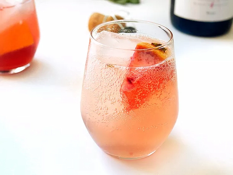 spritzige sangria mit fruchtstücken aus grapefruit als passender sekt cocktail für silvester und feiern