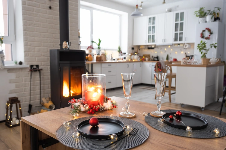 weihnachtlich dekorierter wohnraum mit einbauküche und brennendem pelletofen