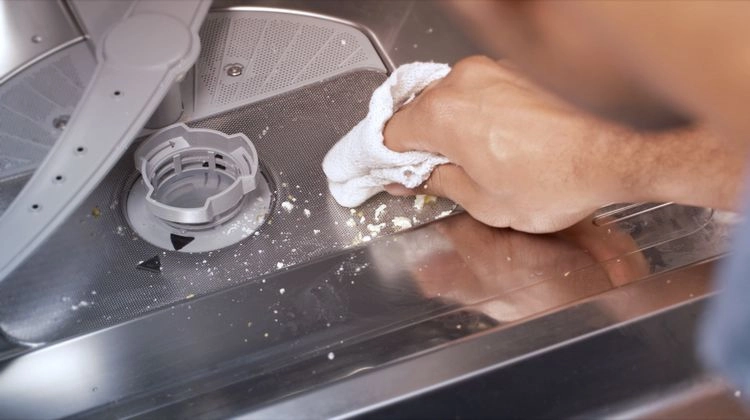 Schmutz und Essensreste von der Spülmaschine entfernen