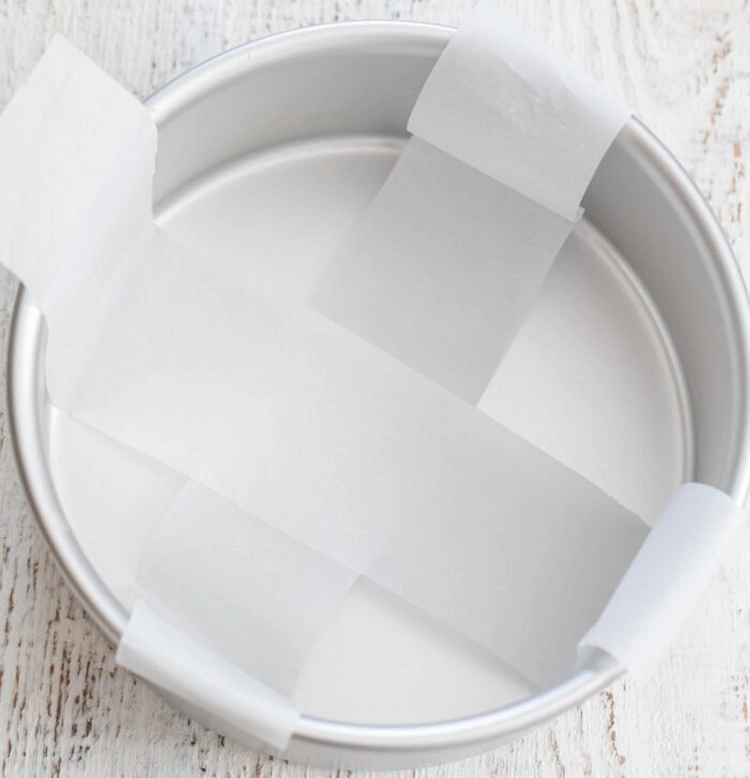 Verwenden Sie Pergamentpapier, um die Backform mit Griffen zu versehen, damit Sie den Kuchen leicht herausholen