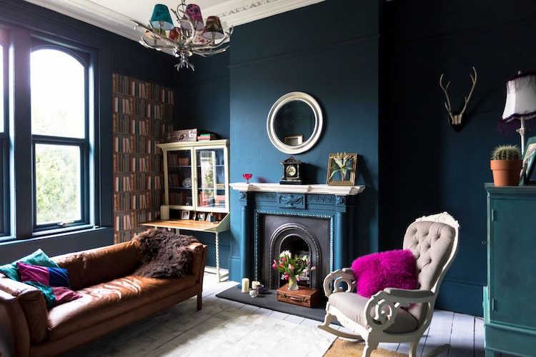 farbige akzente in einem wohnzimmer mit kamin und dunkelblauen wänden italienischer einrichtungsstil