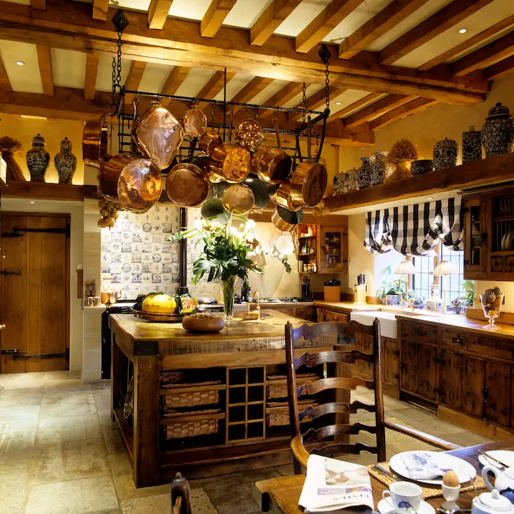 rustikale atmosphäre in einer mediterranen küche mit holzmöbeln und küchenutensilien aus kupfer