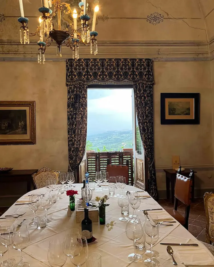 typisch italienischer einrichtungsstil mit großem esstisch und wandbildern an wänden in erdtönen in einer villa