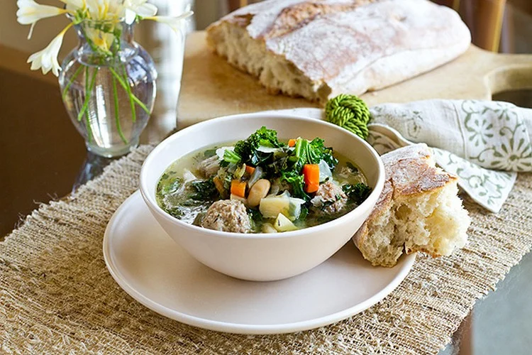 Gesunde Hackbällchen Suppe mit Rindfleisch, Bohnen, Gemüse und frischen Kräutern