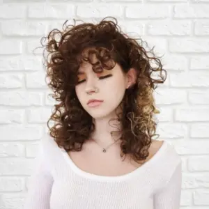 Mittellanger Shag Cut für lockiges Haar inspiriert von den 80ern
