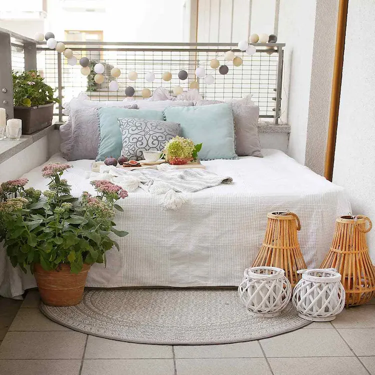 komfortable ecke zum schlafen im freien auf dem balkon mit ruhebett oder liege und einladender dekoration