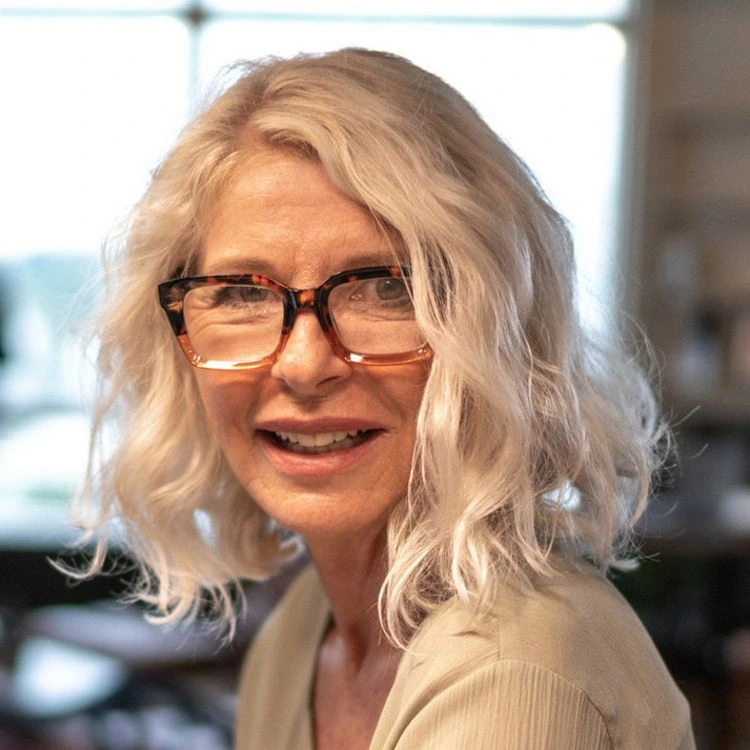 Schicke Frisuren für Frauen ab 50 mit Brille - schulterlanges, lockiges Haar