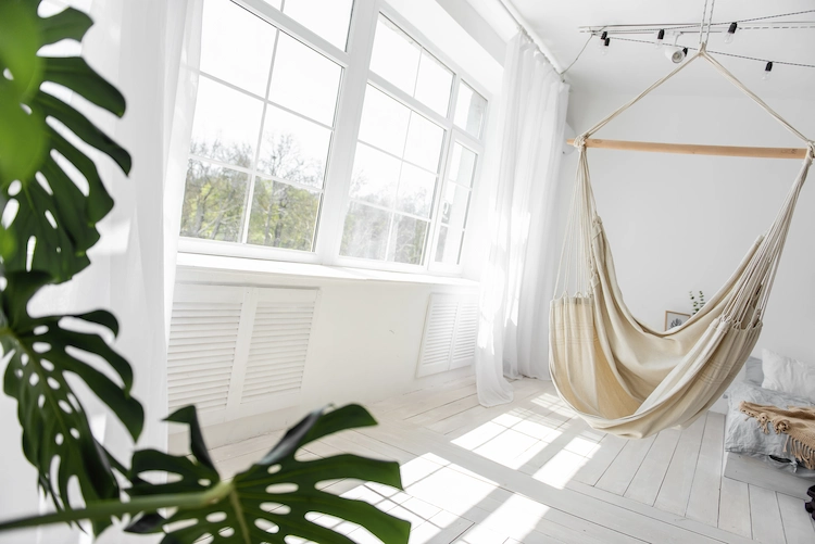 minimalistisch-eingerichtetes-wohnzimmer-mit-haengesessel-und-zimmerpflanze