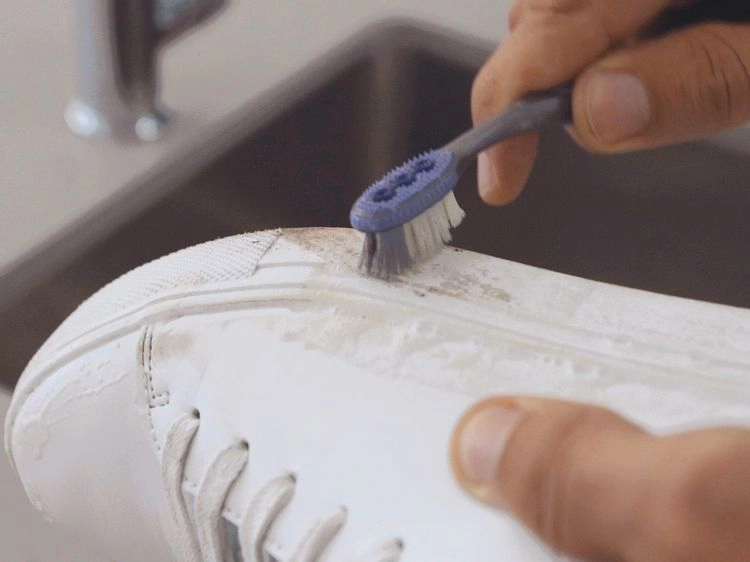 Weiße Sneaker-Sohle mit Zahnpasta sauber machen