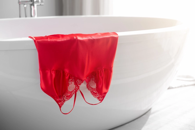 nachthemd in rot auf der badewanne vor duschen ausgezogen lassen