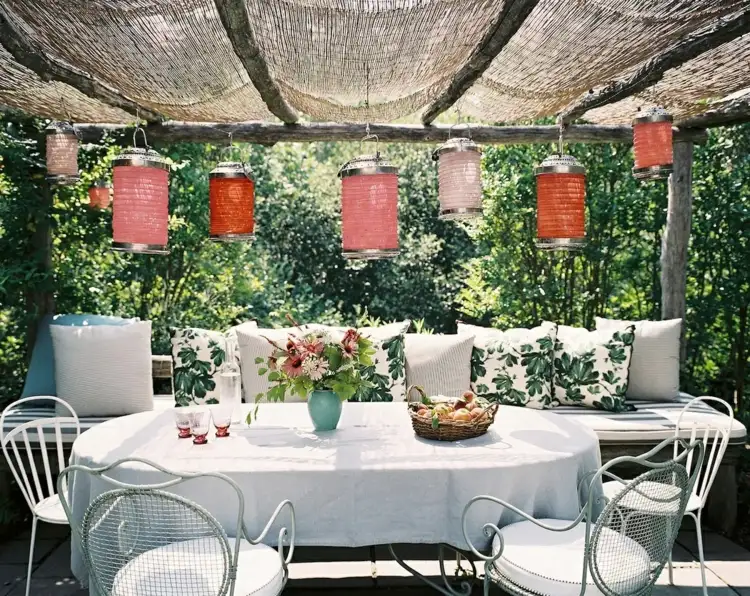 Terrasse im Sommer dekorieren mit Kissen und Laternen zum Aufhängen