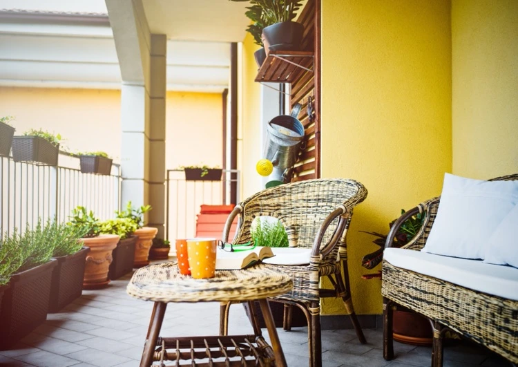 Balkon verschönern Wände gelb streichen Blumenregal dekorieren