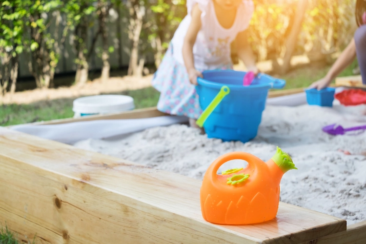 für kleinkinder geeignetes sandspielzeug in einer buddelkiste