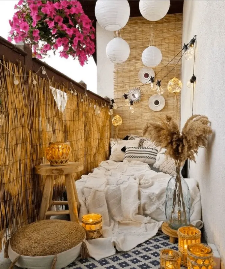 Kleiner Balkon im Boho Stil gestalten mit Bambusmatte für die Wand und das Geländer
