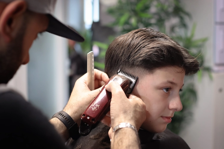 ein haarkünstler stylt einen modernen haarschnitt für teenager