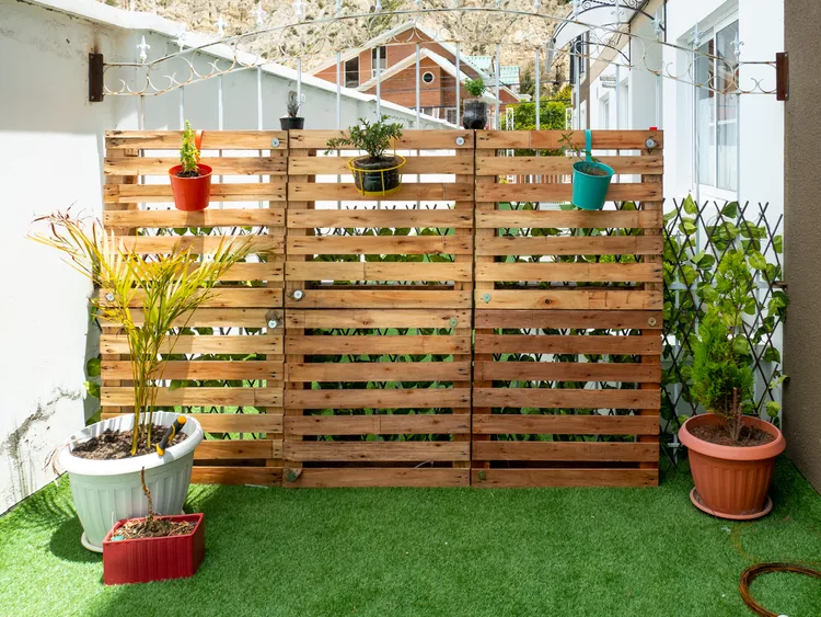 günstige sichtschutzwand oder zaun aus paletten bauen und mit hängenden pflanzgefäßen verschönern