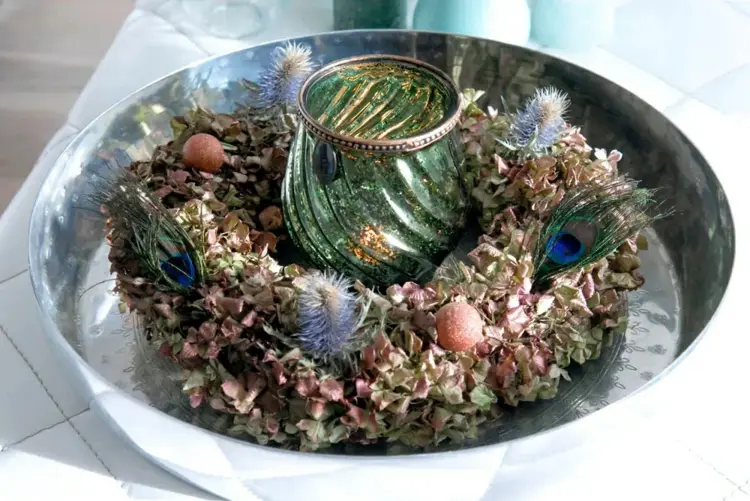 Hortensienkranz binden aus getrockneten Blüten mit Pfauenfedern und Windlicht
