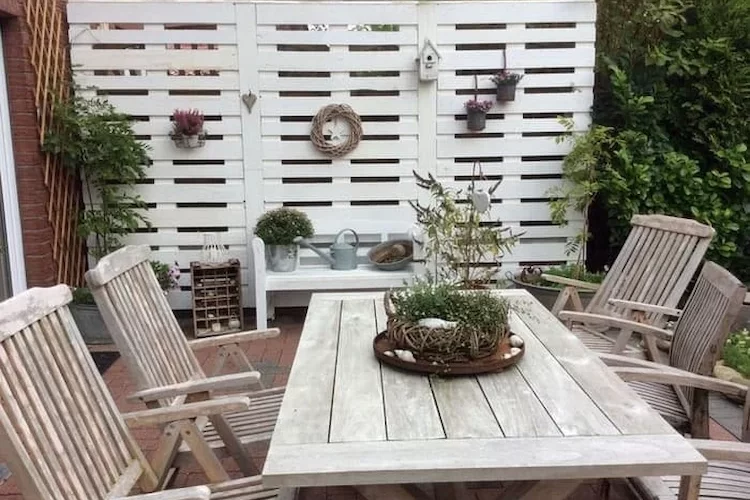 in weiß gestrichener sichtschutzwand mit dekoration neben einem essbereich auf gartenterrasse installieren