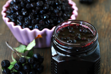 leckere aronia konfitüre neben frischer aronia