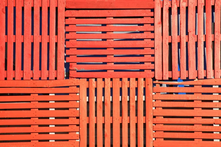 multidirektional aufgestapelten palettenzaun selber bauen und in einem einheitlichen roten farbton bemalen