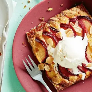 Pflaumenkuchen mit Blätterteig und Streuseln oder Mandeln, serviert mit Eis