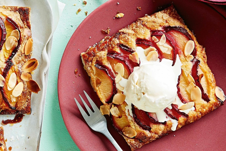 Pflaumenkuchen mit Blätterteig und Streuseln oder Mandeln, serviert mit Eis