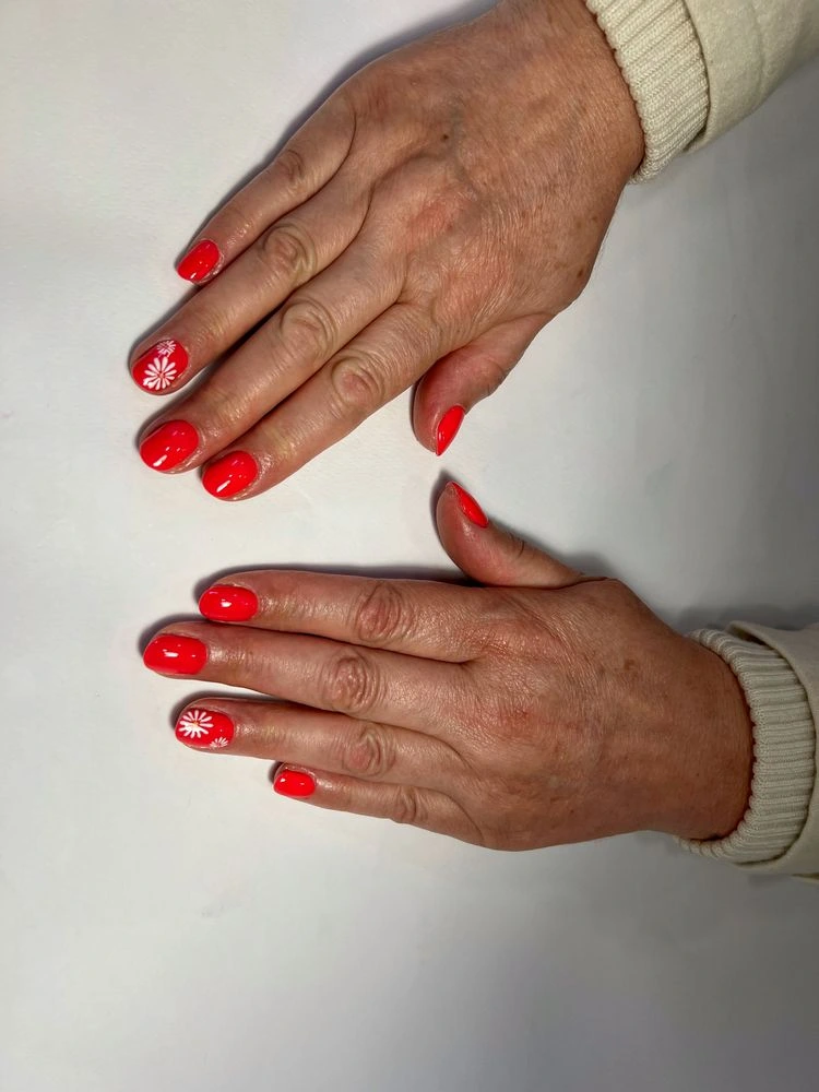 Rote Maniküre mit Blümchen für ältere Damen