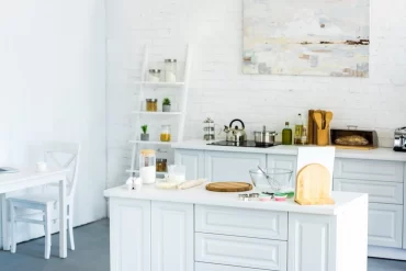 weißer küchenraum mit kücheninsel und wanddekoration für die küche in form von gemälde