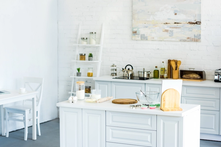 weißer küchenraum mit kücheninsel und wanddekoration für die küche in form von gemälde