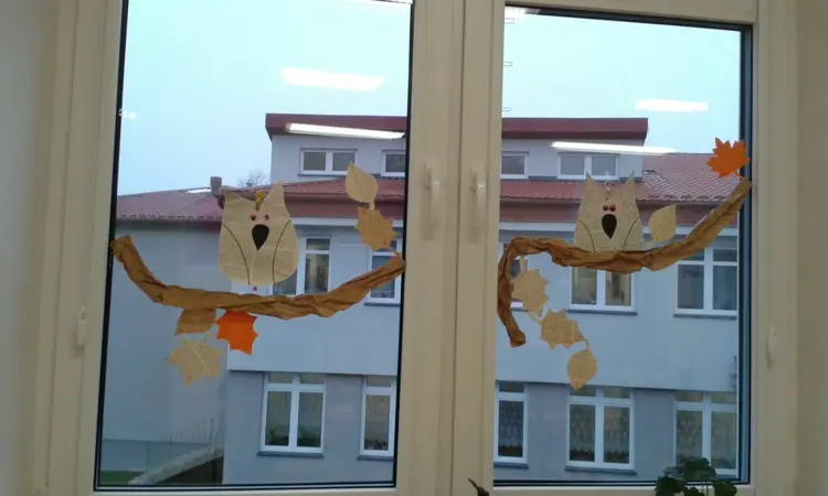 Fensterdeko für den Herbst in der Grundschule - Eule auf einem Ast aus Packpapier