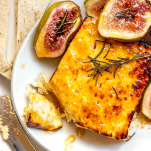 gebackener fetakäse mit honig und rosmarin, auf teller mit gerösteten feigen und pitakbrot