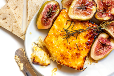 gebackener fetakäse mit honig und rosmarin, auf teller mit gerösteten feigen und pitakbrot
